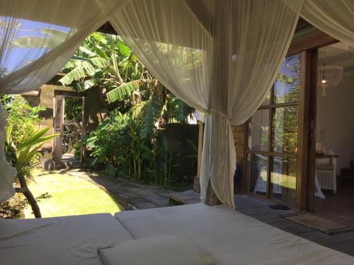 a bedroom with a bed with a canopy at Mangga Wangga Living in Uluwatu