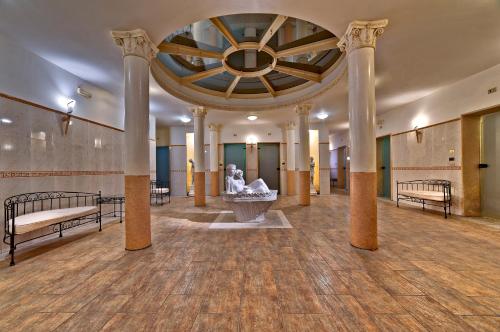 a large room with columns and a fountain in a building at Hotel Terme Patria in Abano Terme
