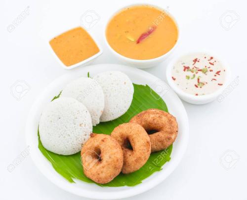 einen Teller mit Donuts und eine Schüssel Dip Sauce in der Unterkunft Shri Gita Hotel in Raipur