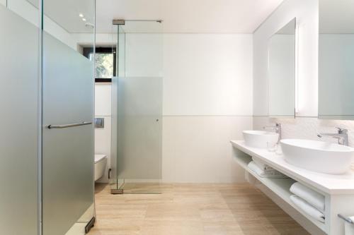 a bathroom with two sinks and a shower at Pine Cliffs Gardens in Albufeira