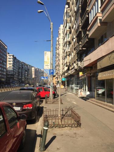 a city street with cars parked on the sidewalk at Roby apartament in Bucharest