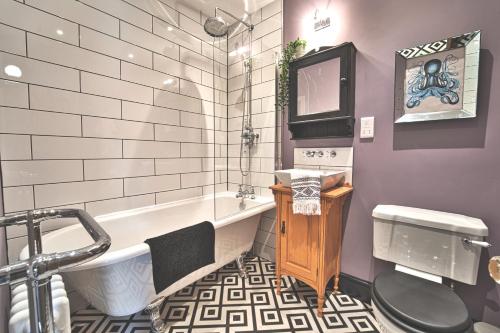 ein Badezimmer mit einer Badewanne und einem Waschbecken in der Unterkunft The Victorian Post House - Central Frome in Frome