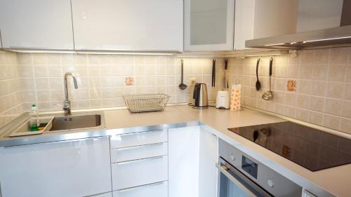 a kitchen with white cabinets and a sink at Apartment Sandy Beach Zambrattia in Zambratija