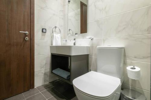 a white bathroom with a toilet and a sink at TONI'S Cute 2BD Apartment in Koukaki! in Athens