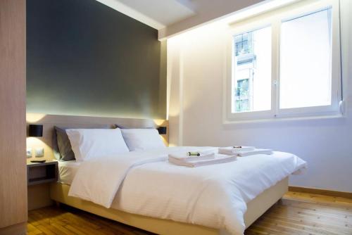 Schlafzimmer mit einem großen weißen Bett und einem Fenster in der Unterkunft TONI'S Fashionable Studio near Presidential Garden in Athen