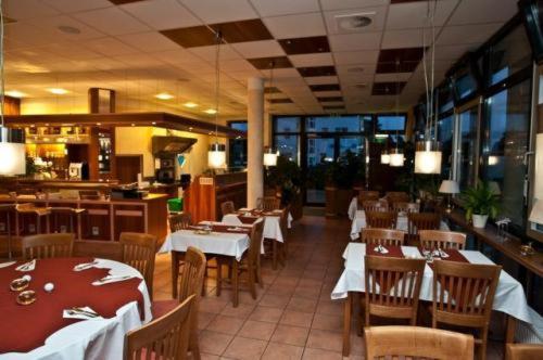 una sala da pranzo con tavoli e sedie e un ristorante di Hotel Manu a Paderborn