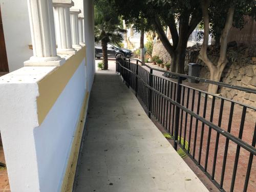 a sidewalk in front of a building with a fence at Casa Glorieta en Villa de Nijar con piscina in Níjar