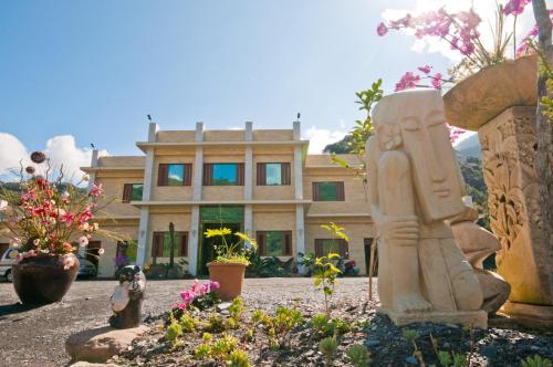 a statue in a garden in front of a house at ChunYang Homestay春陽一品居 in Renai