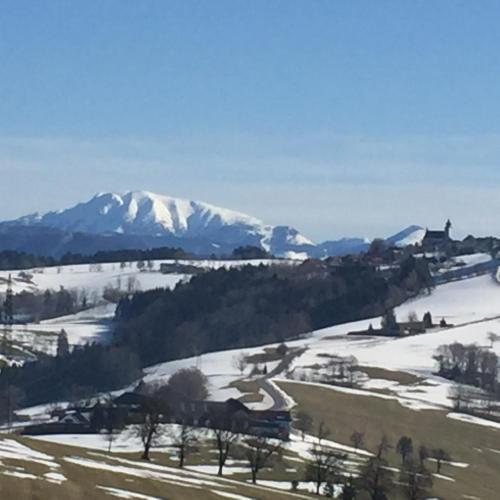 a snow covered mountain in the distance with a train at Ferienwohnungen Kössl in Waidhofen an der Ybbs