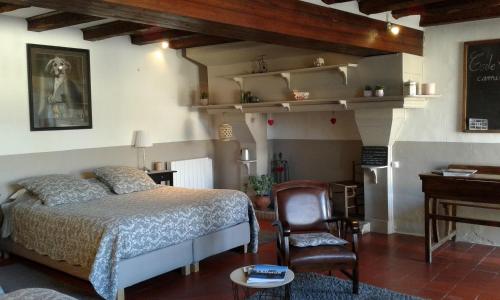 a bedroom with a bed and a desk and a chair at Le Petit Hureau in Saumur