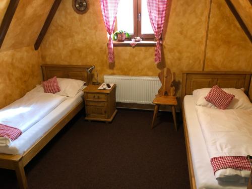 two beds in a small room with a window at Areal Salas in Kajlovec