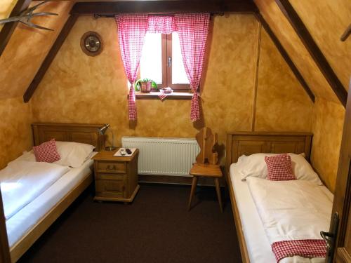 Dos camas en una habitación pequeña con ventana. en Areal Salas, en Kajlovec