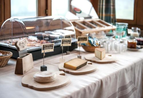 a table topped with cheese and other foods on signs at Schwendi Lodge in Unterwasser