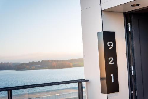 a door to a balcony with a view of a lake at Golden Lakes Hotel in Boussu-lez-Walcourt