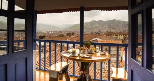 a table on a balcony with a view of a city at Auka Boutique San Blas in Cusco
