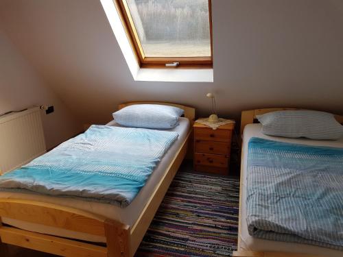 two beds in a small room with a window at Fewo Scherb in Trulben