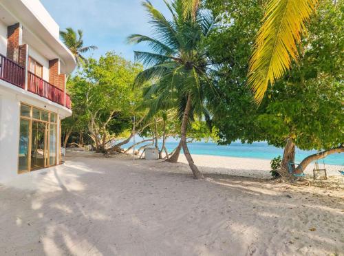 a house on the beach with palm trees and the ocean at Thundi Village & Spa in Maalhos