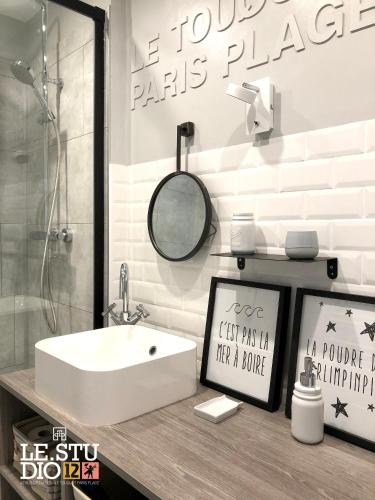 y baño con lavabo blanco y espejo. en Le Studio 12, en Le Touquet-Paris-Plage