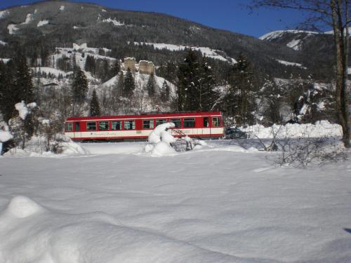 a red and white train in the snow at Gästehaus Scharler in Neukirchen am Großvenediger