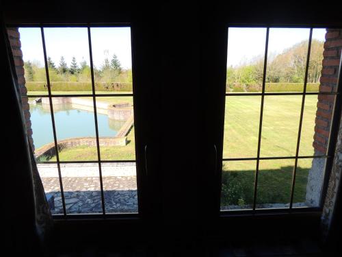an open window with a view of a pool at Chambres d'hôtes La Colinière in Batilly-en-Puisaye
