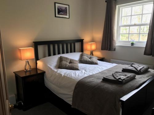 a bedroom with a bed with two lamps on it at Scafell View Apartment, Wasdale, Lake District, Cumbria in Nether Wasdale