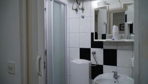 ein Badezimmer mit einem WC, einem Waschbecken und einem Spiegel in der Unterkunft Apartments Nera in Zagreb