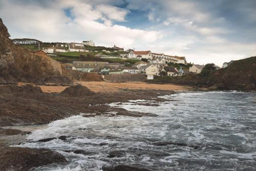 a view of a beach with houses in the background at Hope & Anchor in Hope-Cove