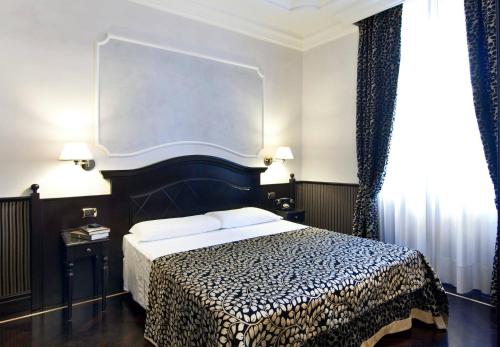 a bedroom with a bed with a black and white blanket at Hotel Best Roma in Rome