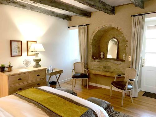 - une chambre avec un lit, une commode et un miroir dans l'établissement Manoir de Rieuzal, à Loubressac