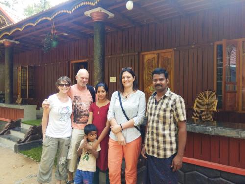 a group of people standing in front of a house at Munroe Meadows in Munroe Island
