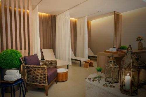 a living room with a chair and a mirror at Bourbon Resort Atibaia in Atibaia
