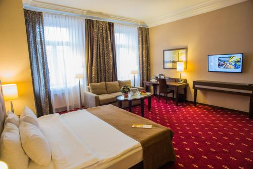 a hotel room with a bed and a table and a desk at Petro Palace Hotel in Saint Petersburg