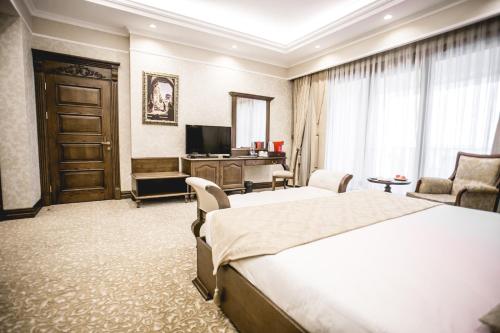 a hotel room with a bed and a desk at Shamakhi Palace Sharadil in Şǝrǝdil