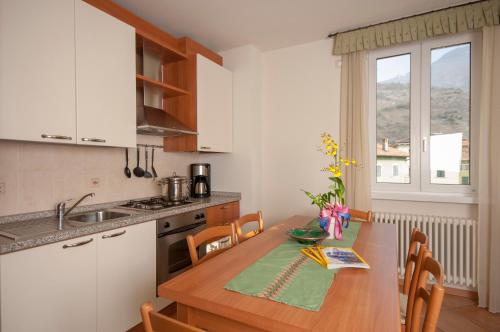 una cucina con tavolo in legno e una cucina con lavandino di Appartamenti Baia Azzurra 4. a Torbole