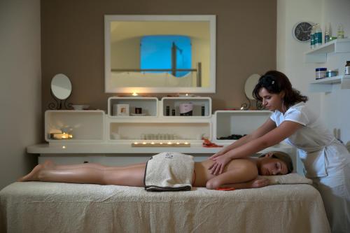 une femme qui donne à une femme un massage sur un lit dans l'établissement Via Capo Rooms, à Sorrente