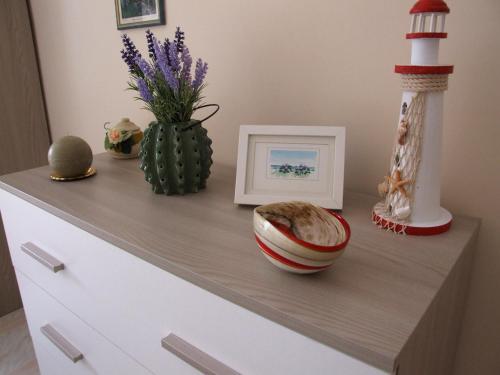 a dresser with a picture and a picture of a cactus at Appartamento Francesco Torre Pali in Torre Pali 