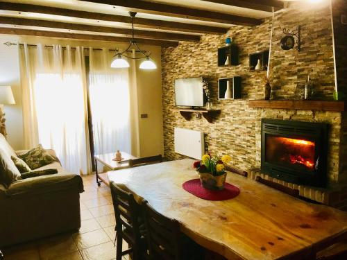 sala de estar con mesa de madera y chimenea en Apartamento Rurales El Mirador de Carboneras, en Carboneras de Guadazaón