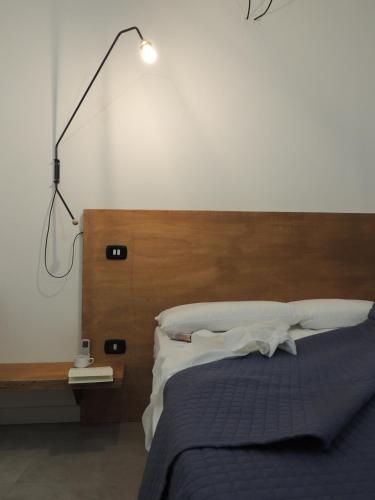 a bedroom with a bed with a light on the wall at Casa Anna in Ilbono