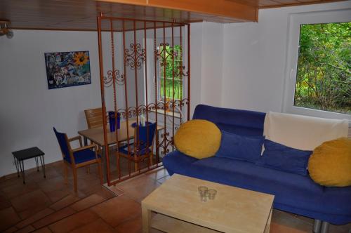 a living room with a blue couch and a table at Ferienwohnung Am Försterteich in Hagenburg