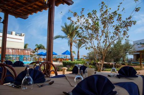 a patio area with chairs and umbrellas at Lahami Bay Resort in Abū Ghuşūn