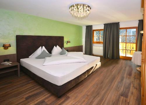 
a bedroom with a bed and a dresser at Hotel Rosengarten in Nova Levante
