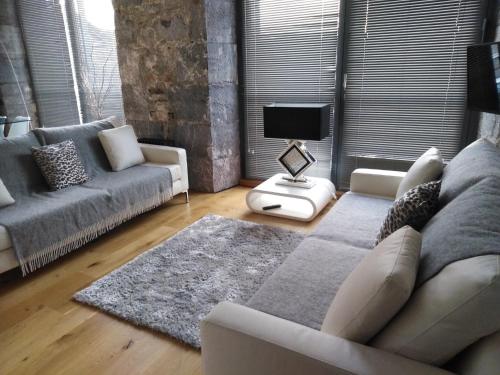 a living room with a couch and a tv at Royal William Yard Apartment in Plymouth