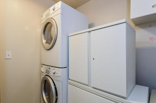 a white laundry room with a washer and dryer at The Five Eleven in Saugatuck