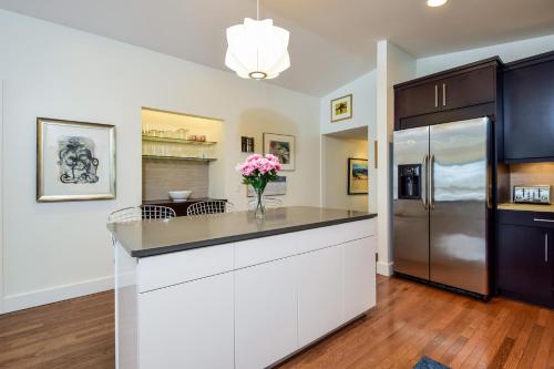 a kitchen with white cabinets and a refrigerator at The Five Eleven in Saugatuck