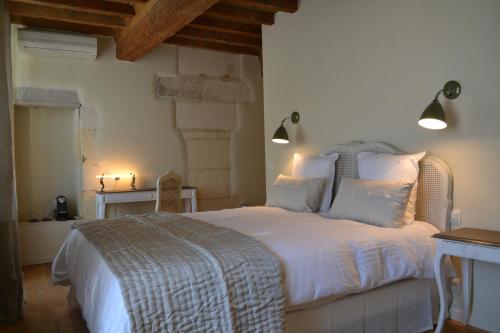 Un dormitorio con una cama grande con sábanas y almohadas blancas. en Mas À l'Improviste, en Saint-Rémy-de-Provence