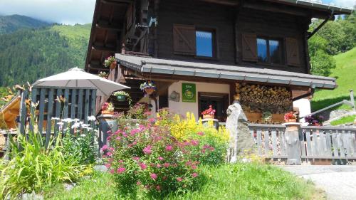 uma casa de madeira com flores em frente em Le nid d'aigle em Arêches