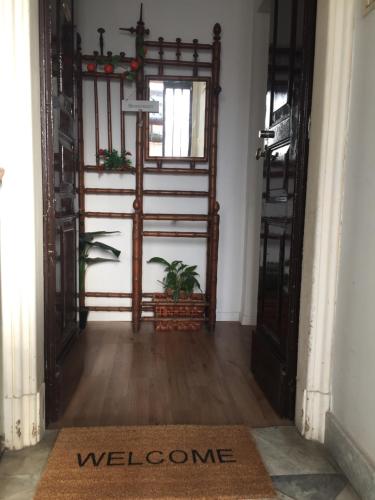 a hallway with an open door with a welcome mat at The Artist's Home Catania Centro in Catania