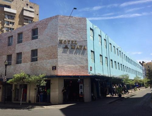 a brick building with a sign on it on a street at Hotel Maya in Guadalajara