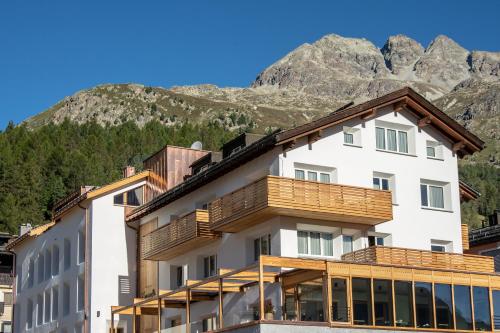 a building with a mountain in the background at Conrad's Mountain Lodge in Silvaplana