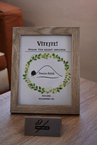 a picture frame with a sign on a table at Pension Růžák in Růžová